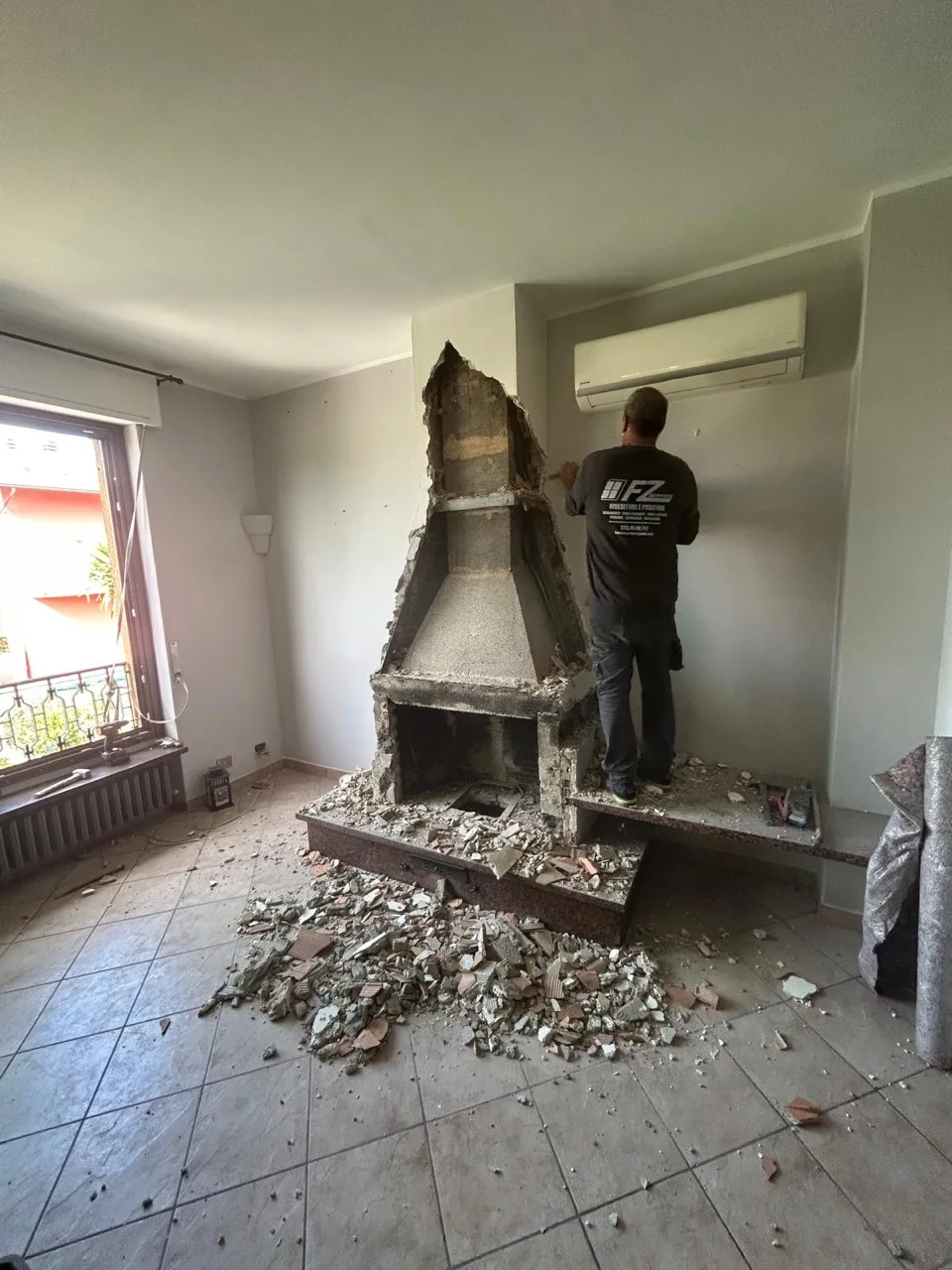 Un operatore FZ Group durante la rimozione del camino.